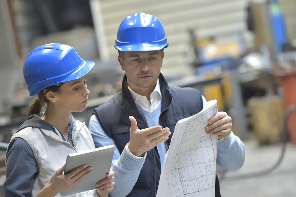 Engineers in mechanical factory reading instructions-3