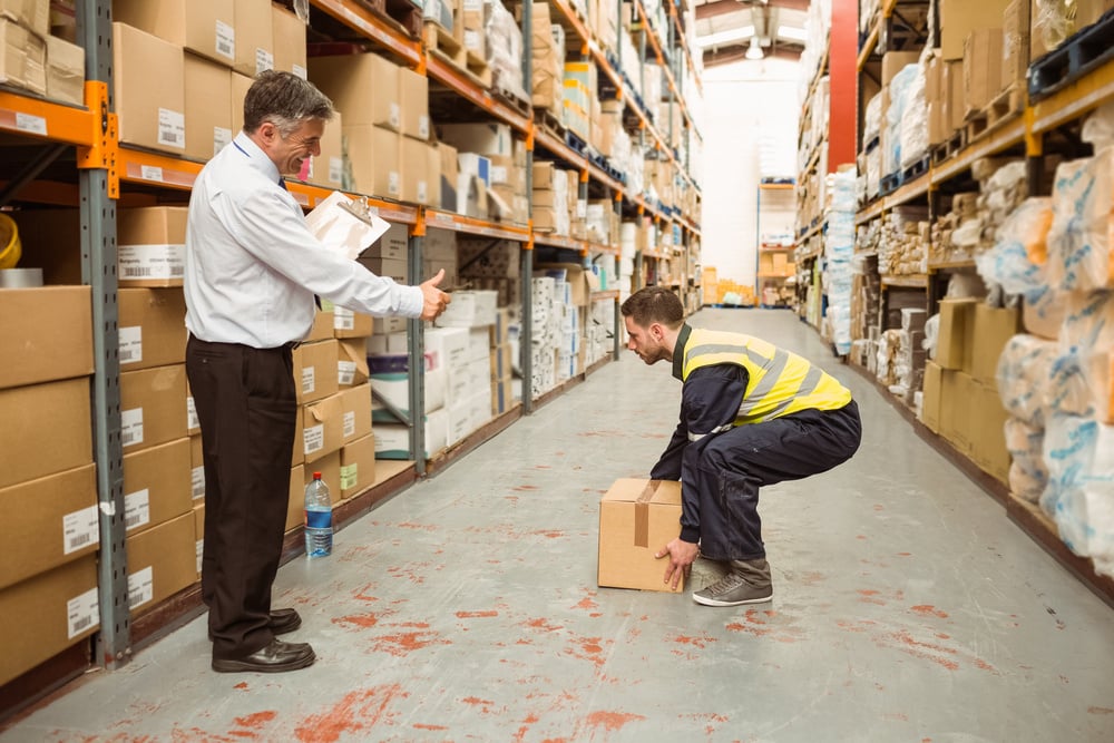 Manager watching worker carrying boxes in a large warehouse-2