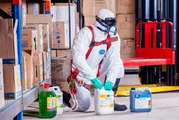 Man%20in%20white%20jumpsuit%20with%20chemicals.jpg?width=600&height=402&name=Man%20in%20white%20jumpsuit%20with%20chemicals.jpg